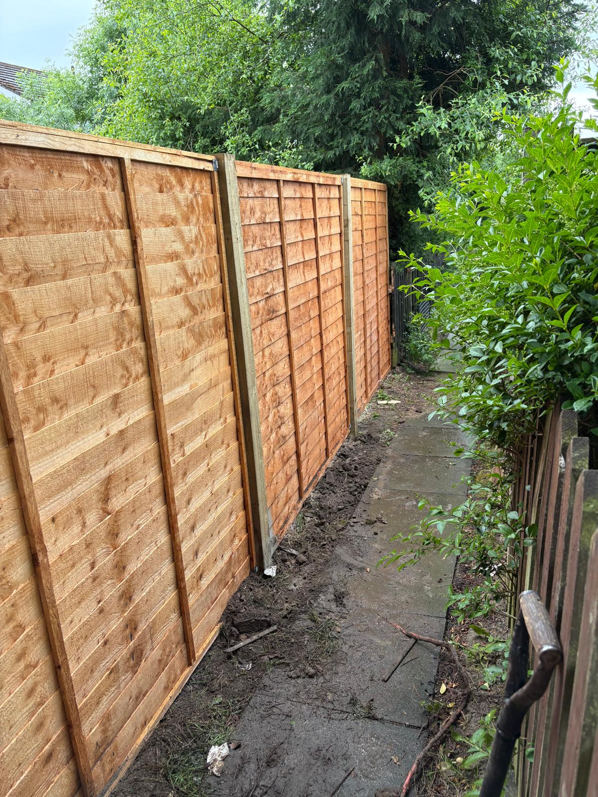 New timber fence after installation along garden path