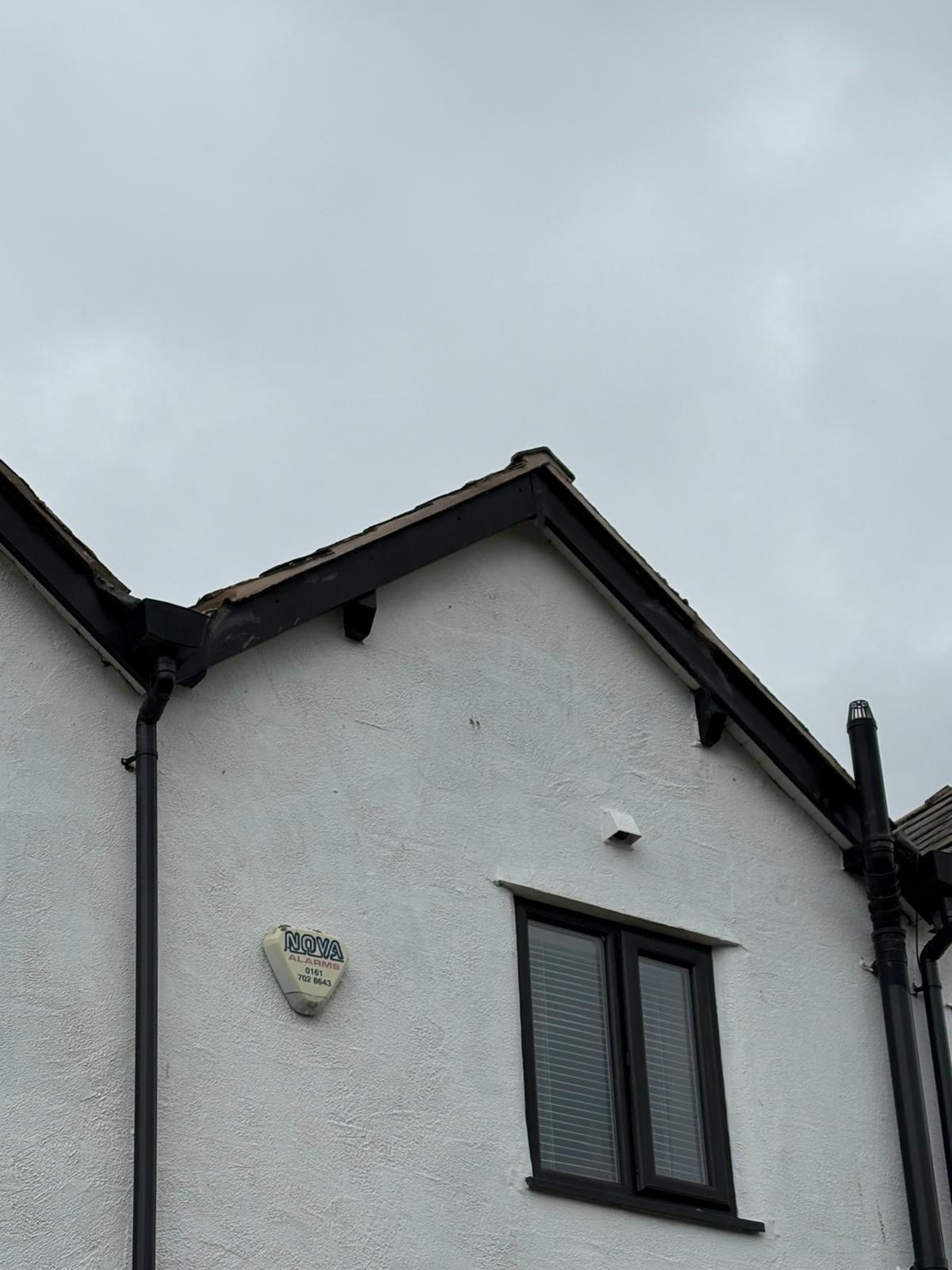 Exterior maintenance work on house gable and roofline